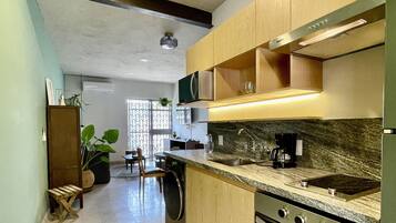 A modern kitchen with wooden cabinets, a built-in oven, and a granite countertop.