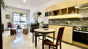 A modern kitchen with wooden cabinets, a built-in oven, and a dining area with a round table and chairs. - Casa San Fernando by Barrio México (Guadalajara)