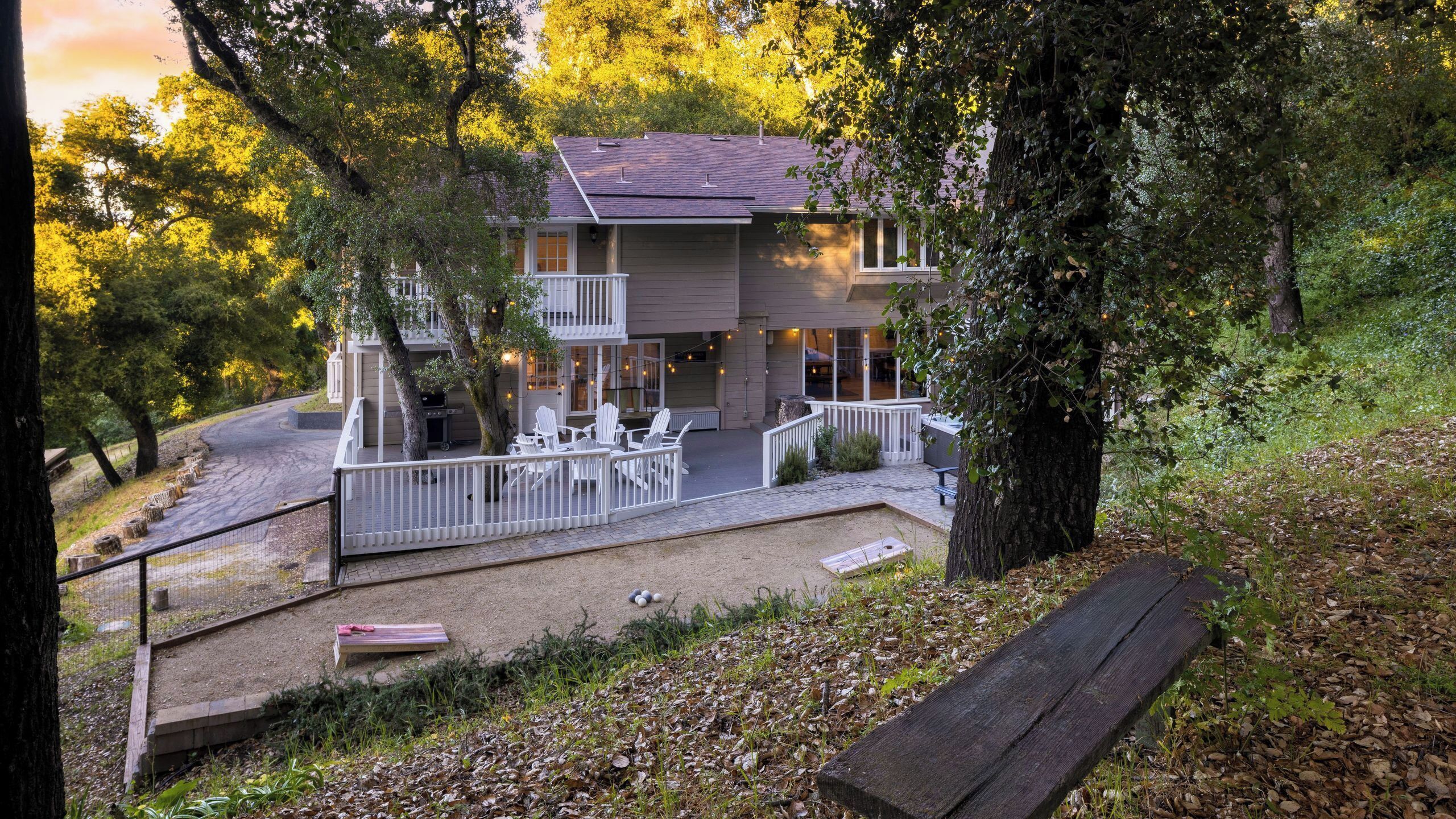 A two-story building with a balcony, outdoor seating, and a barbecue area.