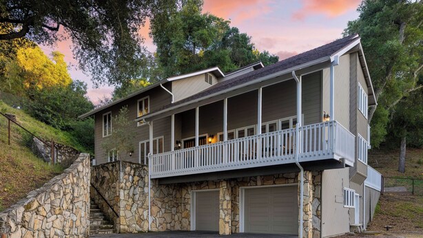 A two-story house with a stone staircase, a balcony, and a garage. - Hidden Oaks Farmhouse by Avantstay Hot Tub, Deck (Atascadero)