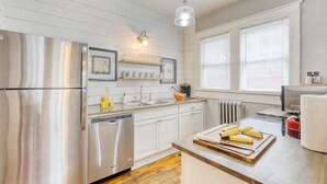 A modern kitchen with stainless steel appliances, white cabinetry, and a wooden countertop. - Heirloom by Avantstay Mins to Downtown Nashville (Nashville)
