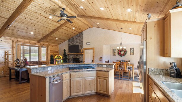Un'ampia cucina con pensili in legno, piani in granito e un'isola centrale.
