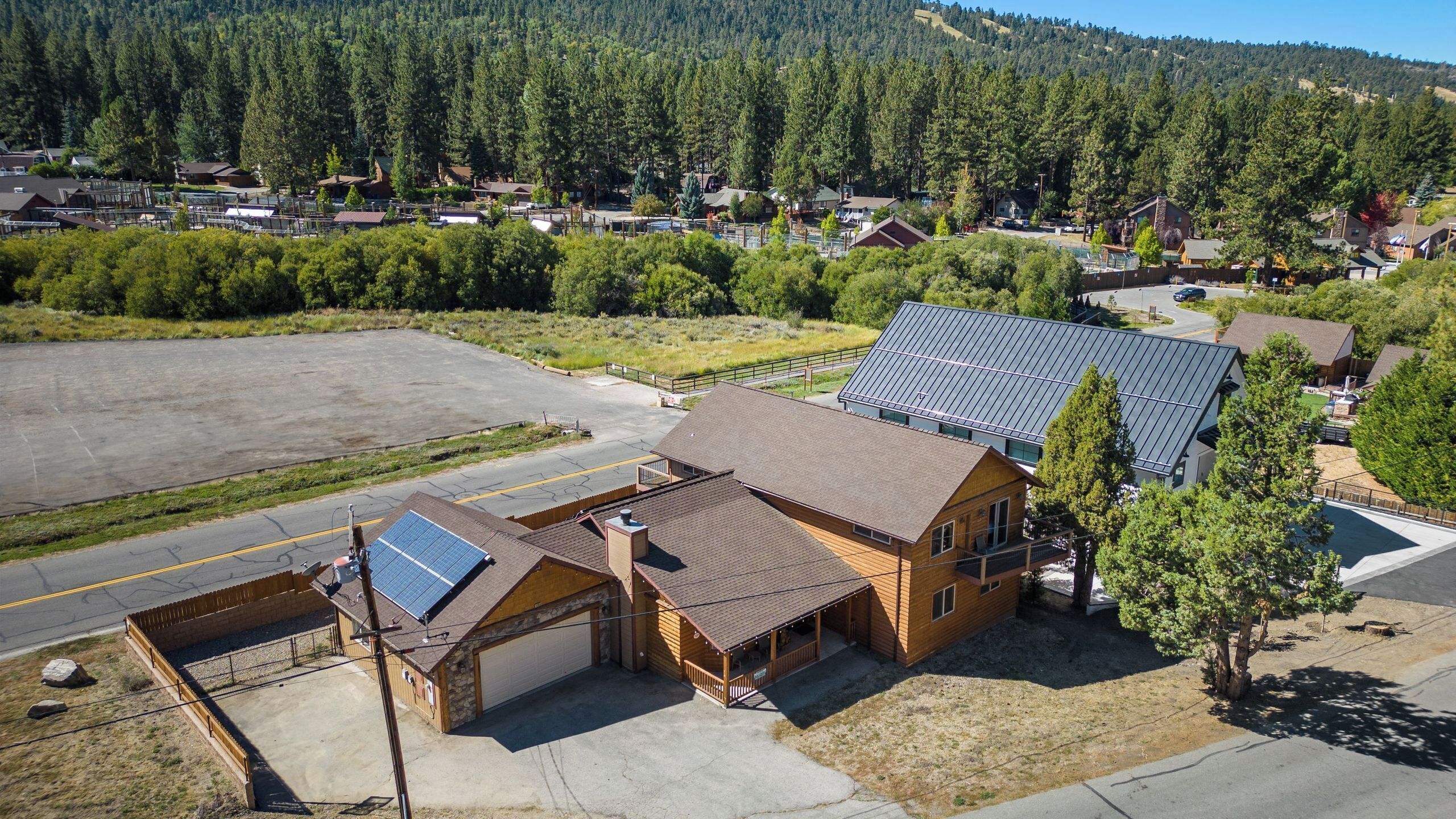 A two-story building with a garage, solar panels, and a covered outdoor area.