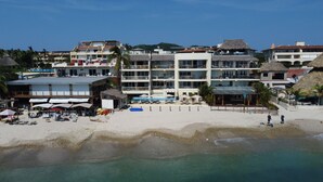 A beachfront hotel with multiple balconies, a pool area, and beachside amenities.
