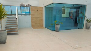 Ein modernes Gebäude mit Glastür, Holztreppe und Topfpflanzen.