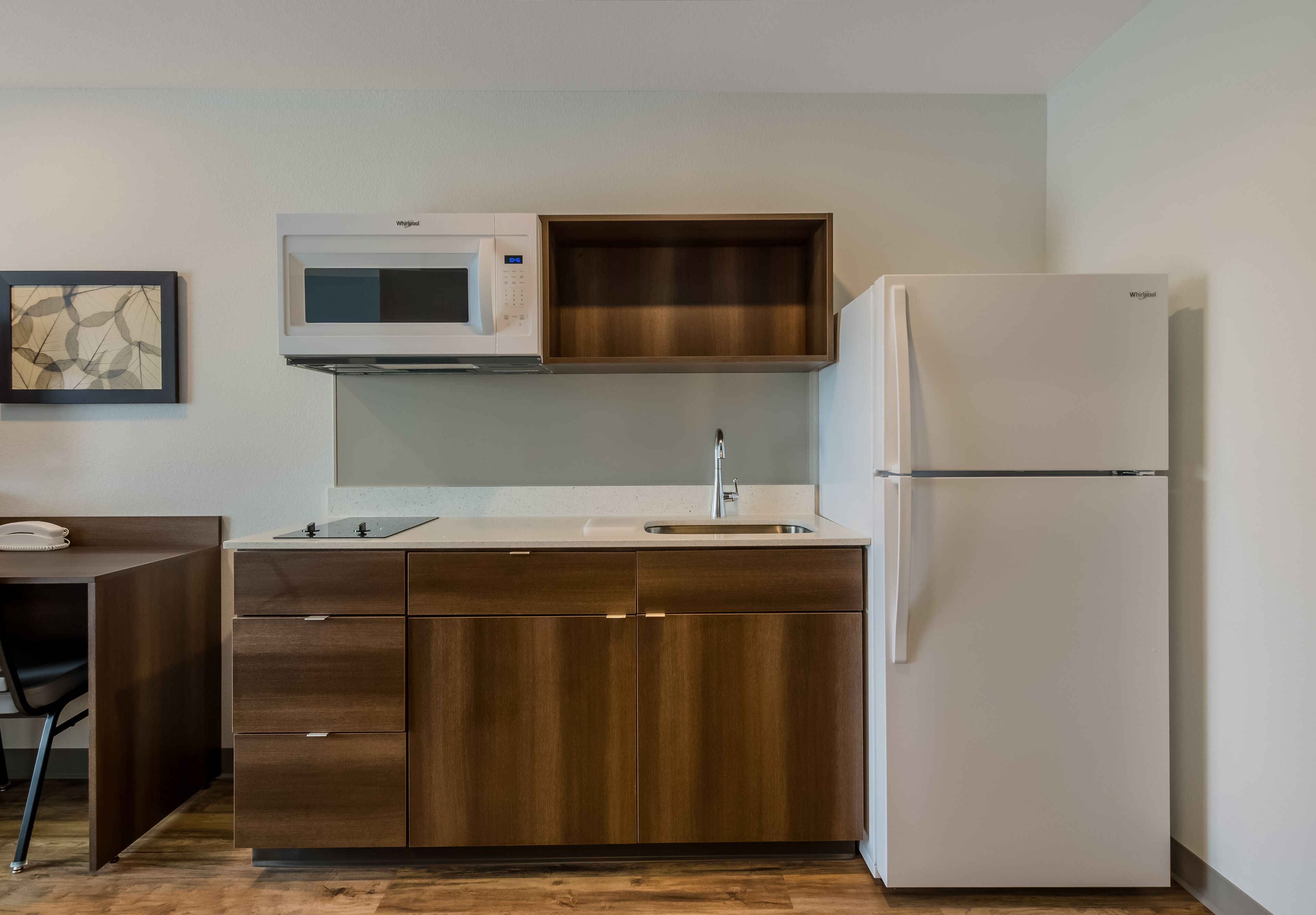 A compact kitchen with a microwave, sink, and refrigerator.