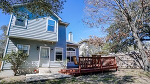 A two-story house with a front porch and a wooden bench. - Ideally Located, Stone Oak Extended Family Stay (San Antonio)