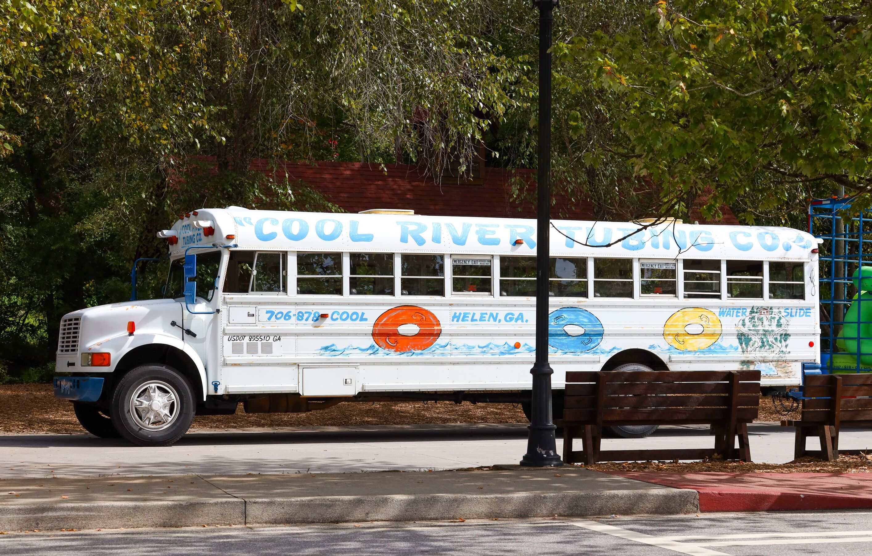 A white bus with "Cool River" and "Helen, GA" on the side, parked on a street.
