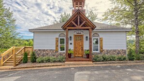 Une petite chapelle avec un clocher en bois, des fondations en pierre et une porte en bois.