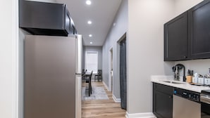 A modern kitchen with a stainless steel refrigerator, black cabinets, and a dishwasher.