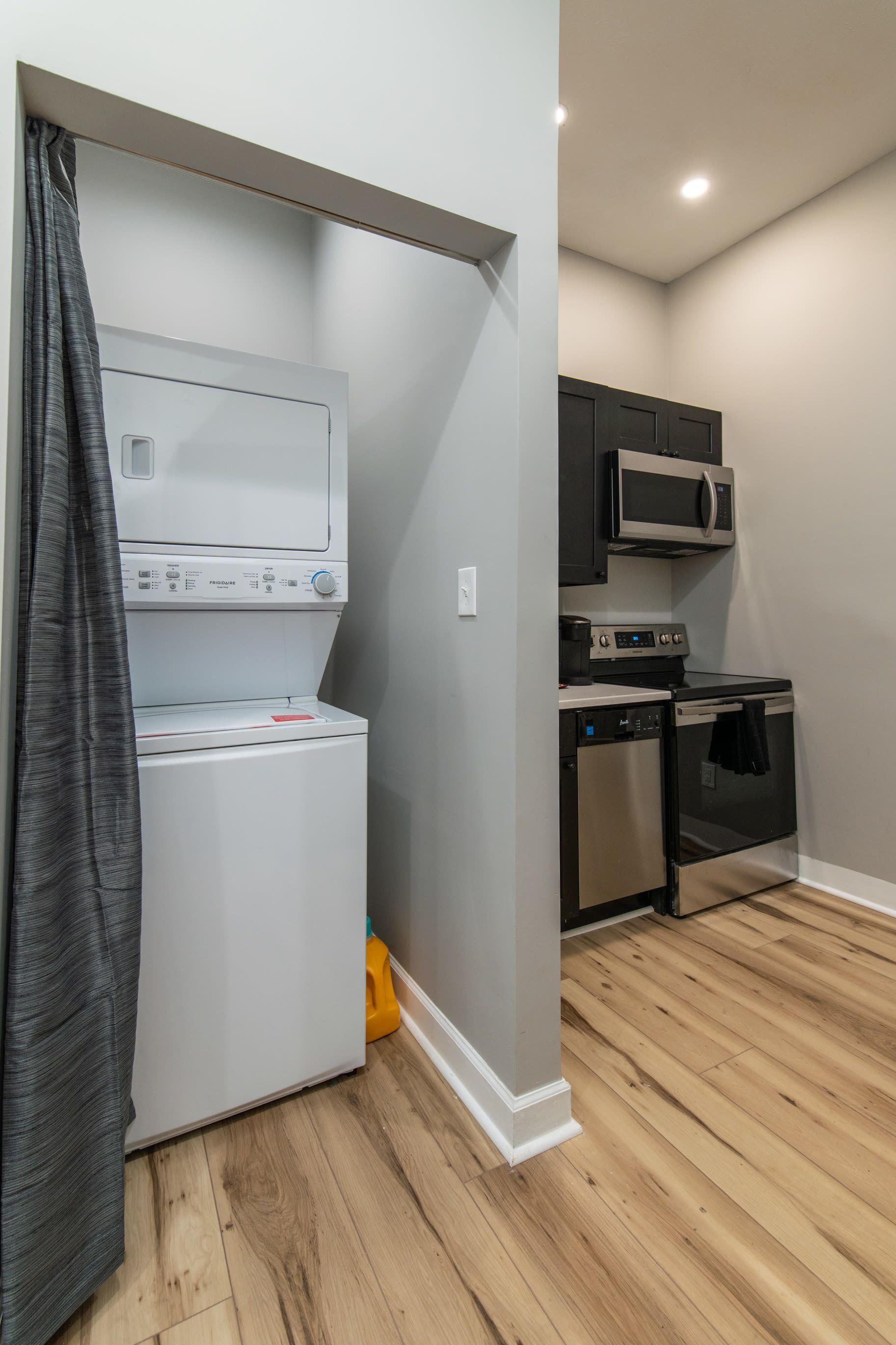 A compact kitchen with a washing machine, microwave, oven, and dishwasher.