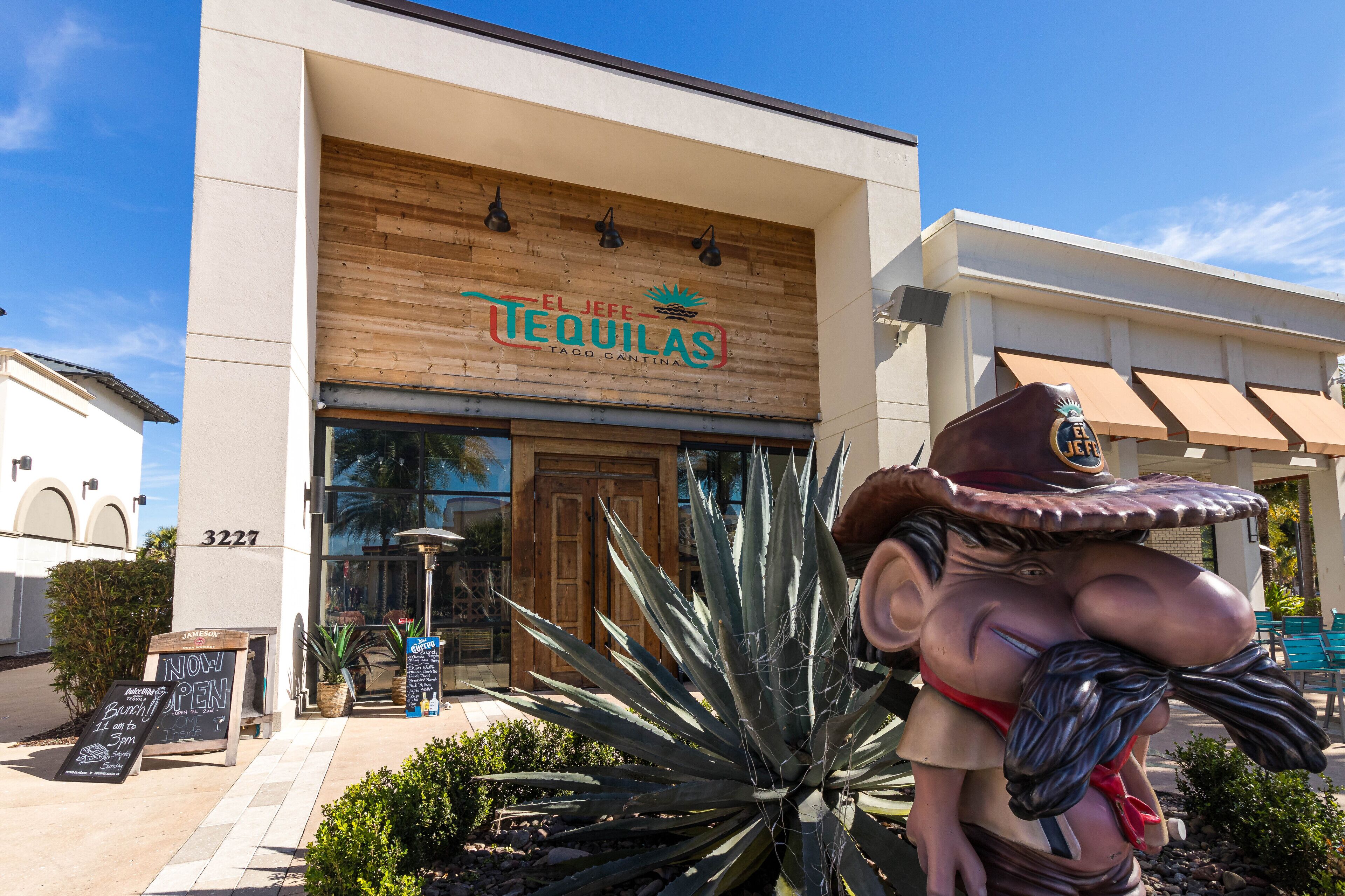 Un restaurant appelé «El Jefe Tequilas», avec une façade en bois et un grand agave en premier plan.