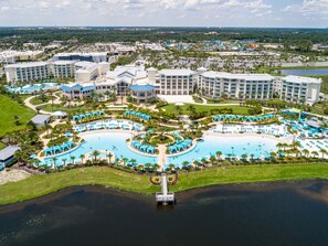 A resort with multiple swimming pools, a dock, and a large building complex.