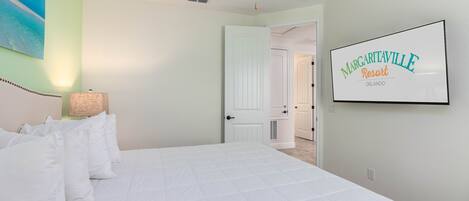 A hotel room with a bed, a ceiling fan, a painting, and a sign for Margaritaville Resort.