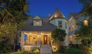 A two-story house with a porch, a small front yard, and a visible front door.