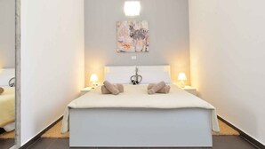 A modern bedroom with a large bed, two bedside lamps, and a zebra-themed artwork on the wall. - Villa mit Pool und Klimaanlage (Žminj)