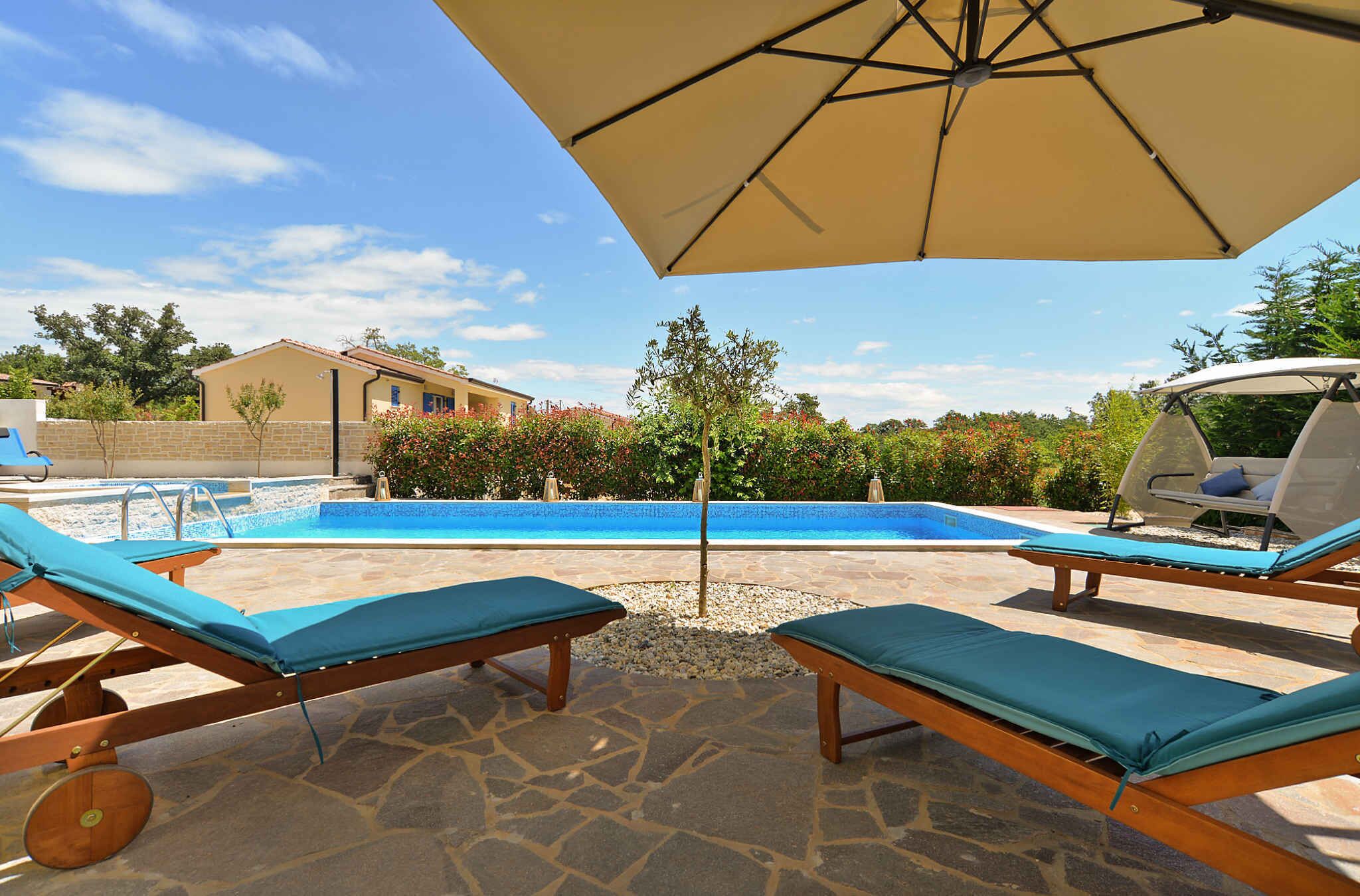 A poolside area with lounge chairs and an umbrella.