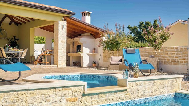 A swimming pool with stone steps, a covered patio area with outdoor furniture, and a stone wall. - Villa mit Pool und Klimaanlage (Žminj)