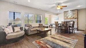 A spacious living room with a sofa, coffee table, and dining area. - Gated Community_Onsite Golf Course_Hot Tub_Air Hockey_Foosball_Board Games_Free SDC Tickets (Reeds Spring)