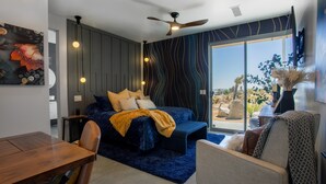 Ein modernes Schlafzimmer mit einem Bett, einem Schreibtisch und Blick ins Freie.