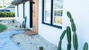 A modern house with a white exterior, black-framed windows, and a wooden door labeled "5306".