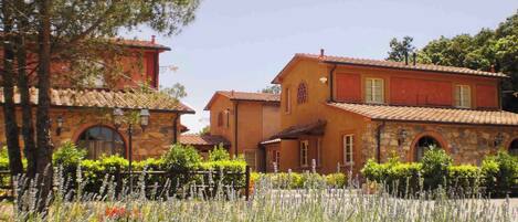 A traditional Mediterranean-style building with stone and stucco exteriors, arched windows, and a tiled roof.