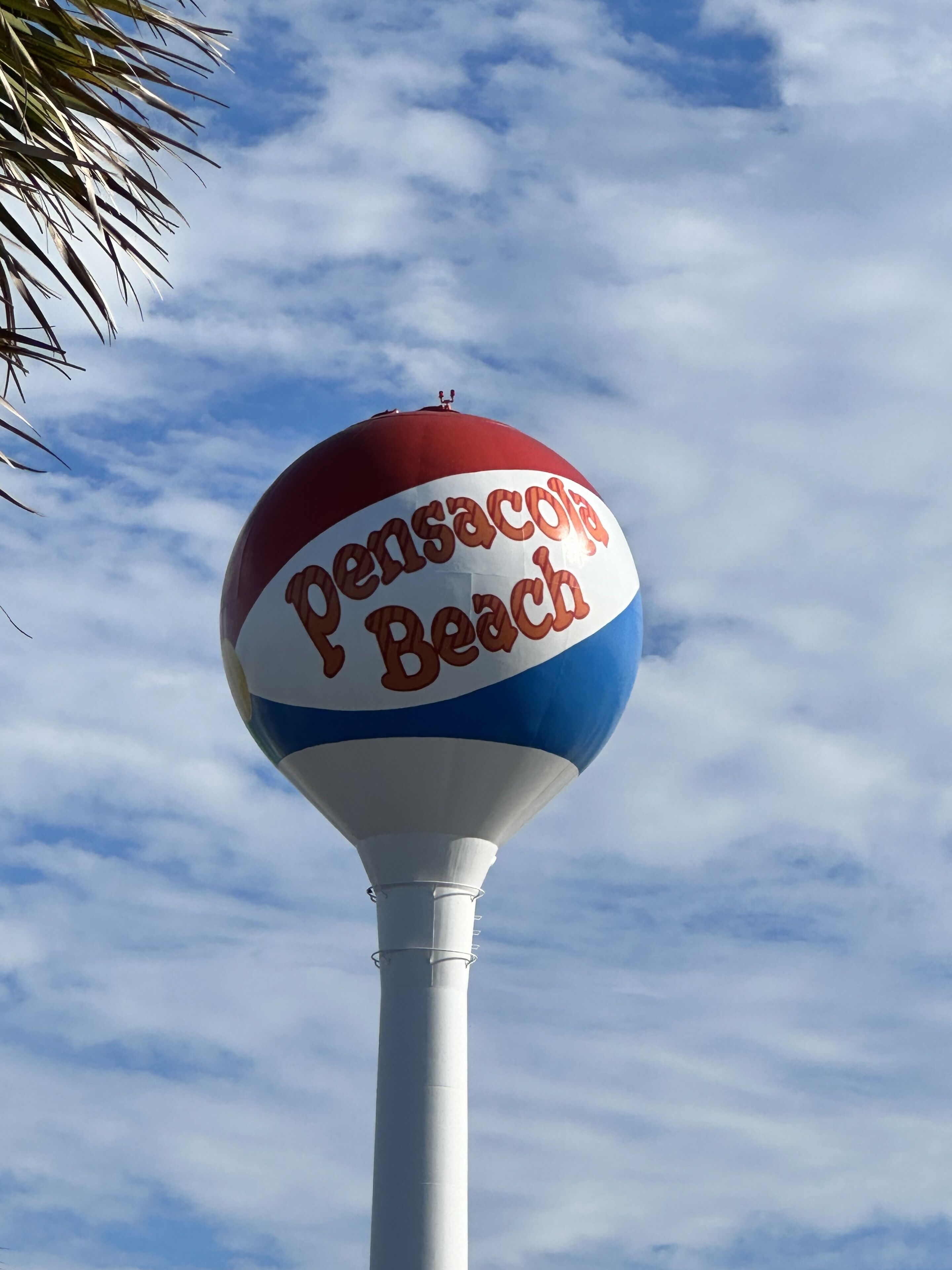 Un panneau sur la plage avec l’inscription « Pensacola Beach ».