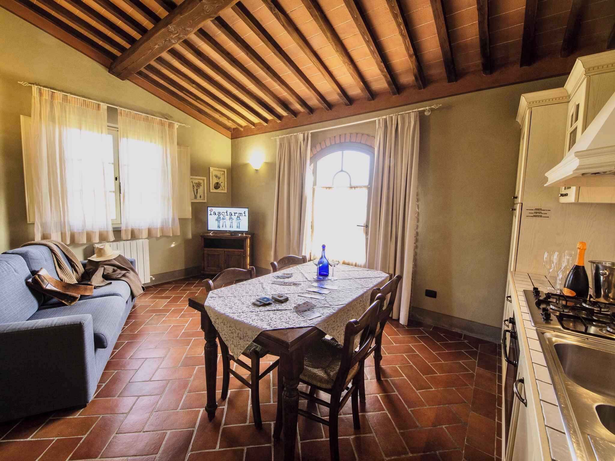 A cozy living room with a sofa, a dining table, and a kitchen area with a stove.
