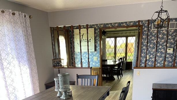 A dining area with a long wooden table, six chairs, and a decorative vase.