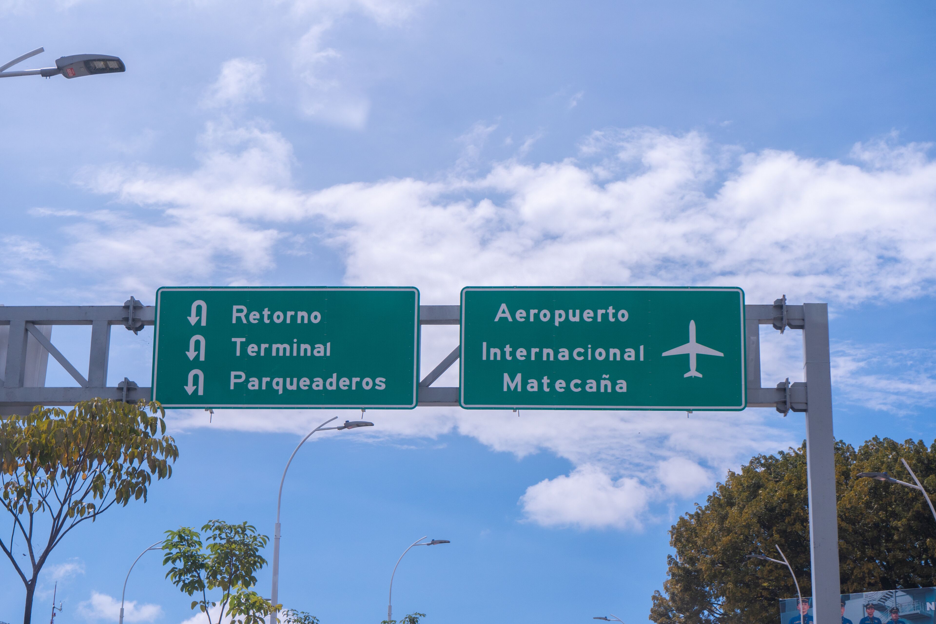 A highway sign with directions to 'Retorno Terminal Parqueaderos' and 'Aeropuerto Internacional Matecana'.