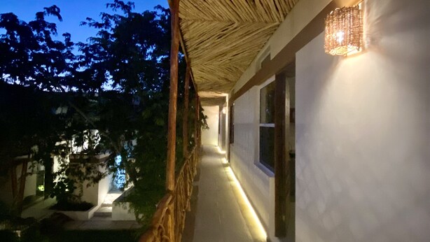 A corridor with a wooden ceiling and a lit wall feature. - Casa Cielito Lindo Cozumel (Cozumel)