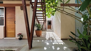 A covered outdoor area with a wooden door, a potted plant, and a staircase. - Casa Cielito Lindo Cozumel (Cozumel)