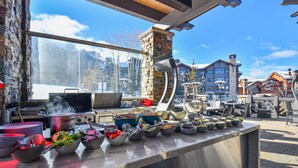 A restaurant with a stone wall and large windows overlooking a snowy mountain. - Powder Peak by Avantstay Ski In And Out (Park City)