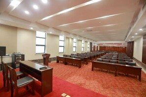 A conference room with rows of chairs, a podium, and a carpeted floor. - Fengyang International Hotel (Fengyang)