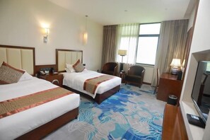 A hotel room with two beds, a TV, a desk, and a chair. - Fengyang International Hotel (Fengyang)