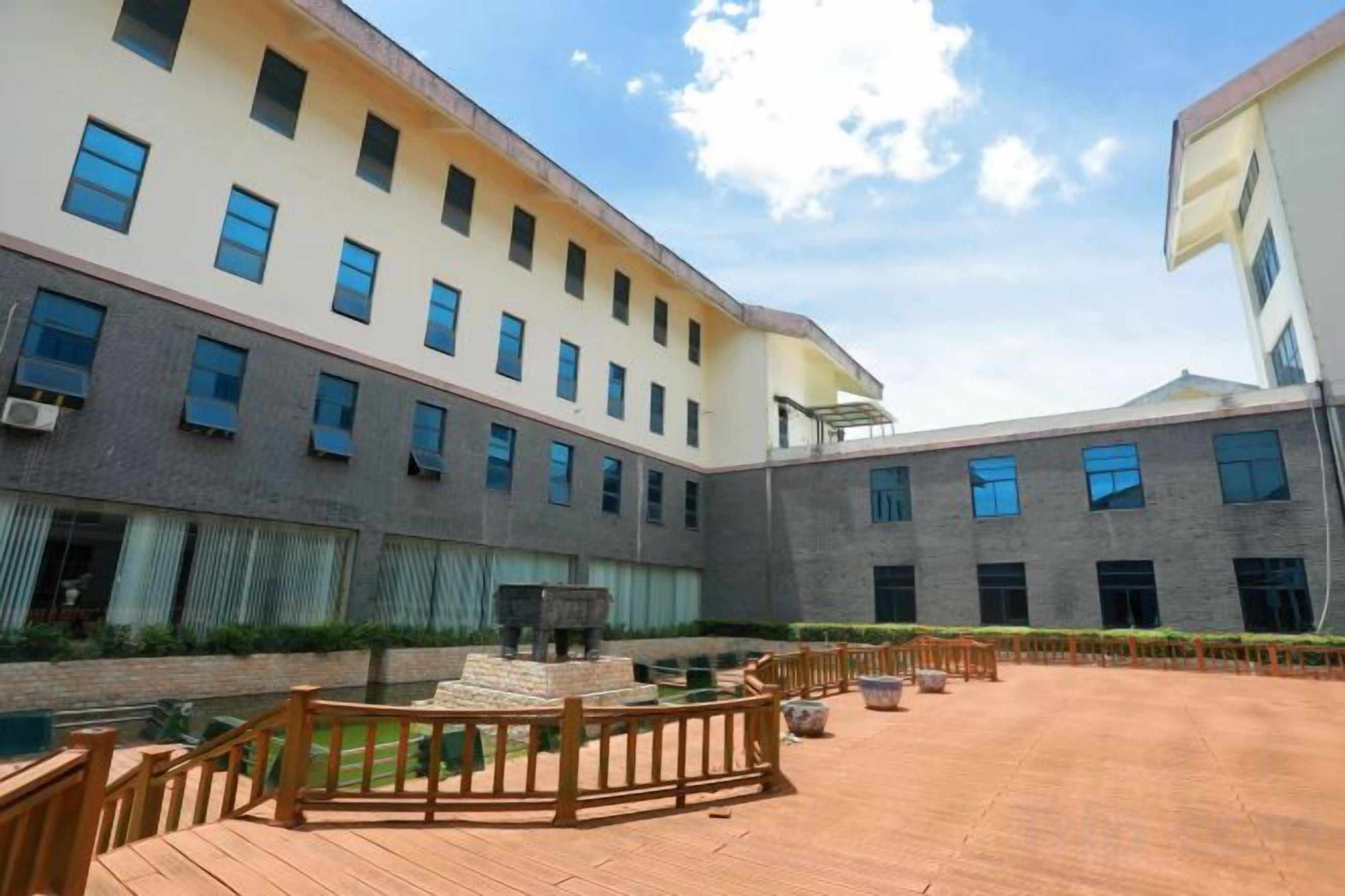 Une cour avec une fontaine, une piscine et un bâtiment doté de nombreuses fenêtres.
