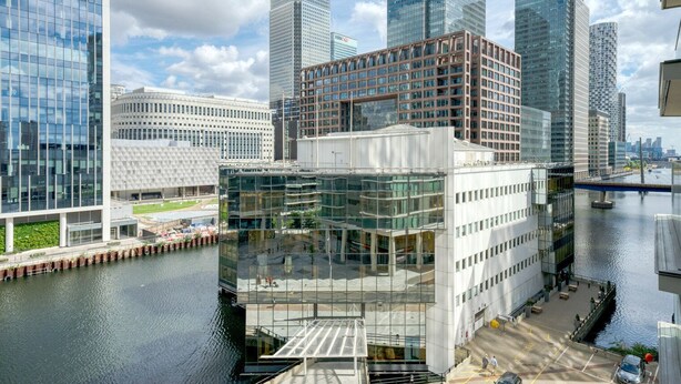 A modern urban area with high-rise buildings, a river, and a bridge. - Bright Canary Wharf 1BR, steps to South Quay light rail, by Blueground (London)