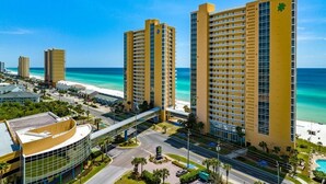 A high-rise hotel with multiple floors, a beach view, and a parking area.