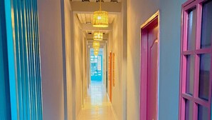 A hallway with a ceiling fan, a chandelier, and doors on both sides. - Tropical Hostel Santa Marta (Santa Marta)
