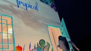 A building with a mural of tropical leaves and a sign reading "Tropical Hostel". - Tropical Hostel Santa Marta (Santa Marta)