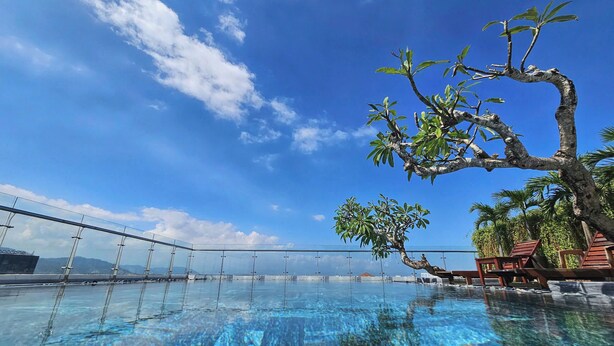 A clear blue sky, a swimming pool, and a tree with green leaves. - LAM Apartment & Hotel Danang (Da Nang)