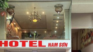 Entrada de un hotel con un cartel que dice "HOTEL NAM SON".