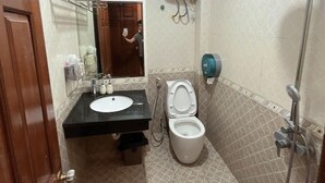Un baño con lavamanos, inodoro y ducha.