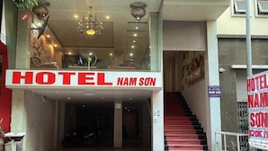 Entrada de un hotel con un letrero llamativo que dice "HOTEL NAM SON".
