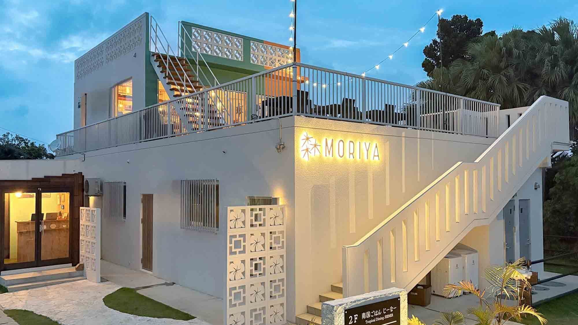 Un edificio moderno con un letrero que dice 'MORIYA' y una escalera que lleva a un balcón.