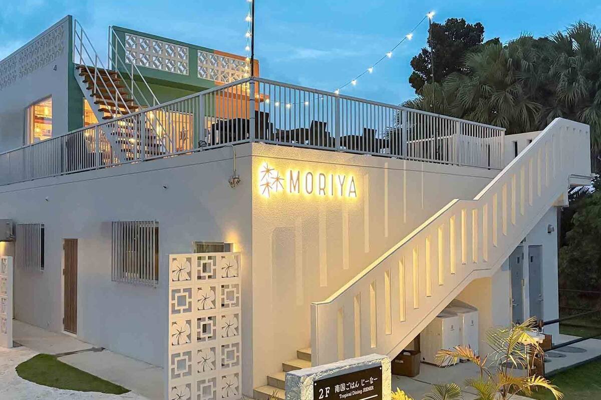 A modern building with a sign reading 'MORIYA' and a staircase leading to a balcony.
