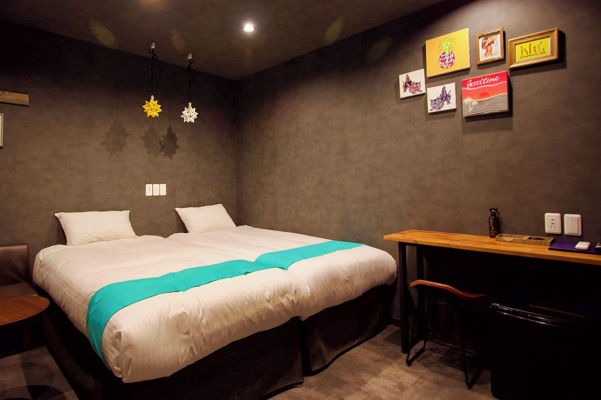 Un dormitorio con cama, escritorio, silla y sofá.