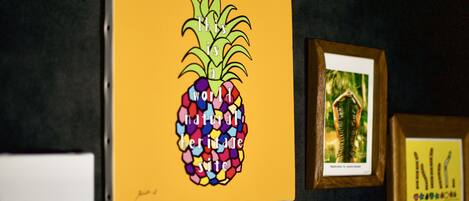 Una obra de arte enmarco con una piña colorida sobre fondo amarillo.