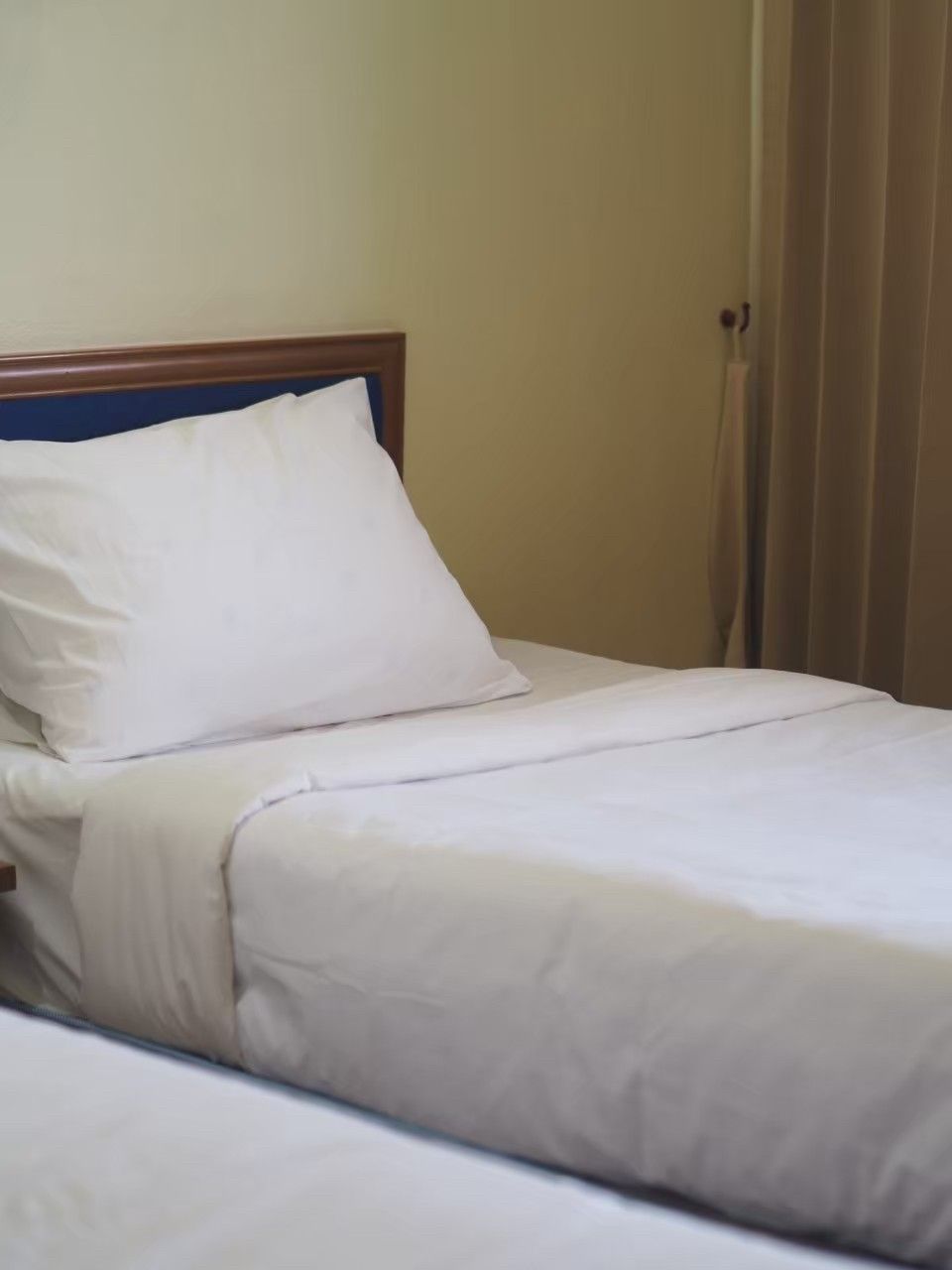 A bed with white bedding and a wooden headboard.