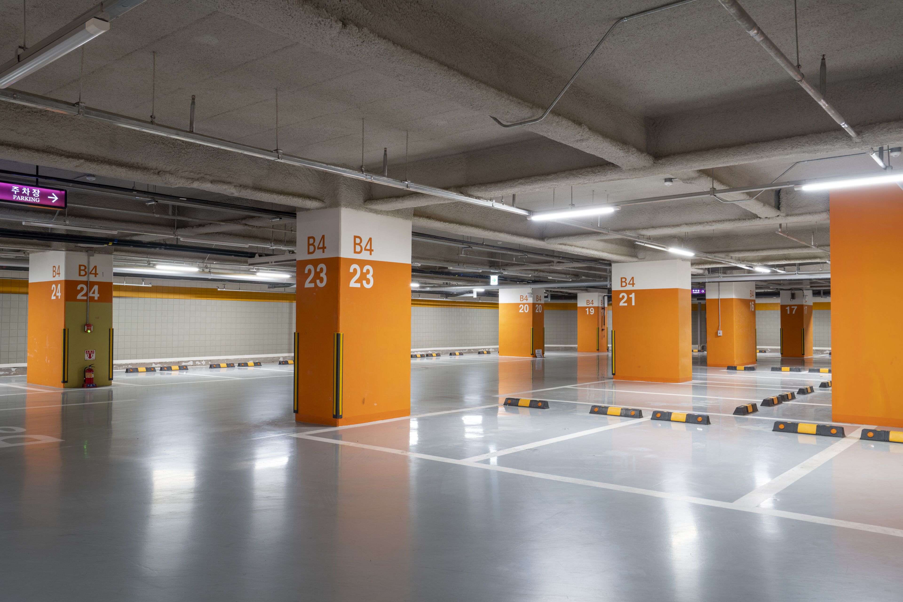 A multi-level parking garage with clearly marked parking bays and directional signs.